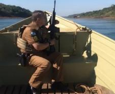 De baixo de sol escaldante, PM’s levam motocicletas apreendidas em barco a remo pelo Rio Paraná em Foz do Iguaçu (PR)