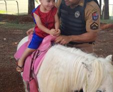 Cão de faro e pôneis fazem alegria das crianças de escola londrinense durante visita da PM