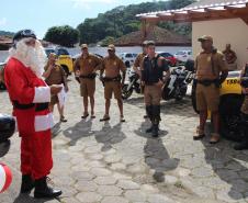 PM promove ação de Natal e encanta veranistas com entrega de doces e pintura de rosto em Guaratuba (PR), no Litoral do estado