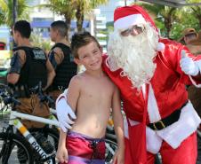 PM promove ação de Natal e encanta veranistas com entrega de doces e pintura de rosto em Guaratuba (PR), no Litoral do estado