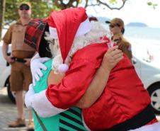 PM promove ação de Natal e encanta veranistas com entrega de doces e pintura de rosto em Guaratuba (PR), no Litoral do estado