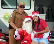 PM promove ação de Natal e encanta veranistas com entrega de doces e pintura de rosto em Guaratuba (PR), no Litoral do estado