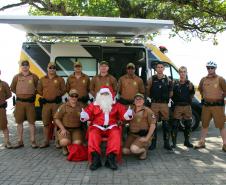 PM promove ação de Natal e encanta veranistas com entrega de doces e pintura de rosto em Guaratuba (PR), no Litoral do estado