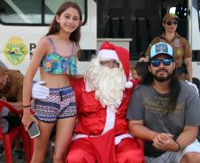 PM promove ação de Natal e encanta veranistas com entrega de doces e pintura de rosto em Guaratuba (PR), no Litoral do estado