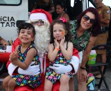 PM promove ação de Natal e encanta veranistas com entrega de doces e pintura de rosto em Guaratuba (PR), no Litoral do estado