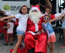 PM promove ação de Natal e encanta veranistas com entrega de doces e pintura de rosto em Guaratuba (PR), no Litoral do estado