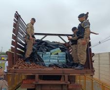 Após buscas detalhadas, os militares estaduais localizaram aproximadamente 5.100 quilos de maconha escondidos sob um carregamento de mandioca