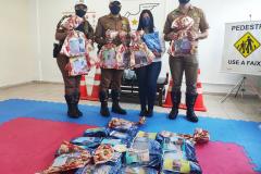 Policiais do BPTran apadrinham 28 alunos de colégio Municipal de Pinhais, na RMC, e entregam presentes de Natal