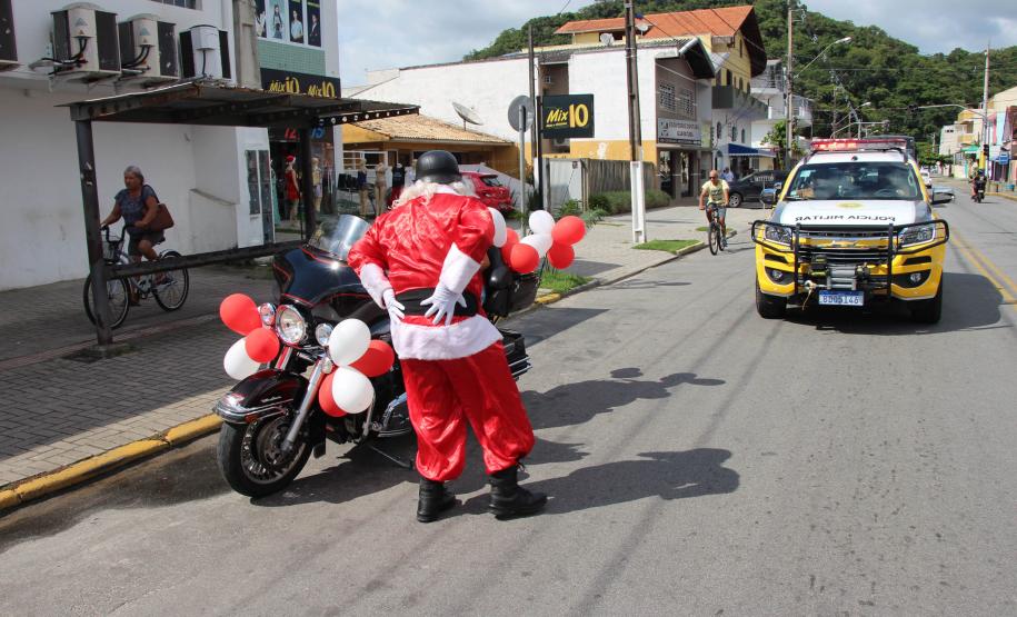 PM promove ação de Natal e encanta veranistas com entrega de doces e pintura de rosto em Guaratuba (PR), no Litoral do estado
