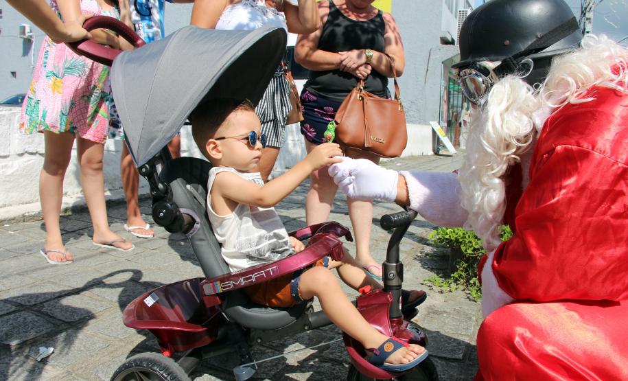 PM promove ação de Natal e encanta veranistas com entrega de doces e pintura de rosto em Guaratuba (PR), no Litoral do estado