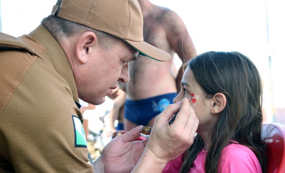 PM promove ação de Natal e encanta veranistas com entrega de doces e pintura de rosto em Guaratuba (PR), no Litoral do estado