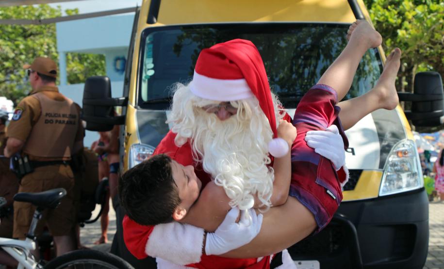 PM promove ação de Natal e encanta veranistas com entrega de doces e pintura de rosto em Guaratuba (PR), no Litoral do estado