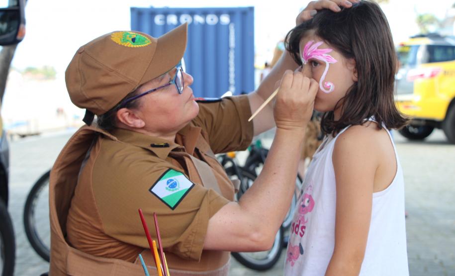 PM promove ação de Natal e encanta veranistas com entrega de doces e pintura de rosto em Guaratuba (PR), no Litoral do estado