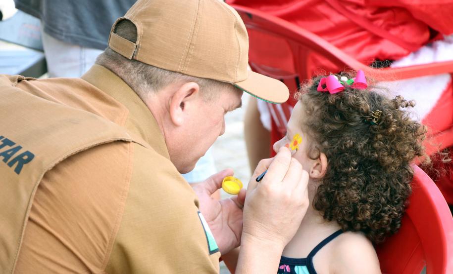 PM promove ação de Natal e encanta veranistas com entrega de doces e pintura de rosto em Guaratuba (PR), no Litoral do estado