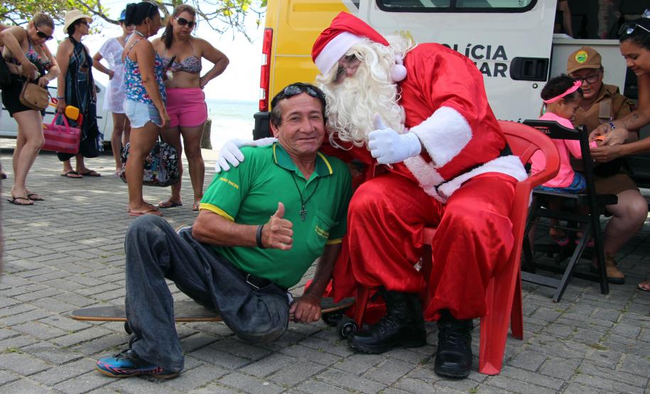 PM promove ação de Natal e encanta veranistas com entrega de doces e pintura de rosto em Guaratuba (PR), no Litoral do estado