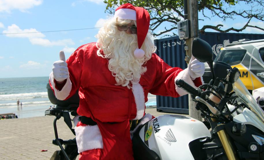 PM promove ação de Natal e encanta veranistas com entrega de doces e pintura de rosto em Guaratuba (PR), no Litoral do estado