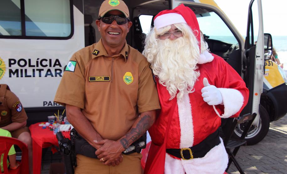 PM promove ação de Natal e encanta veranistas com entrega de doces e pintura de rosto em Guaratuba (PR), no Litoral do estado