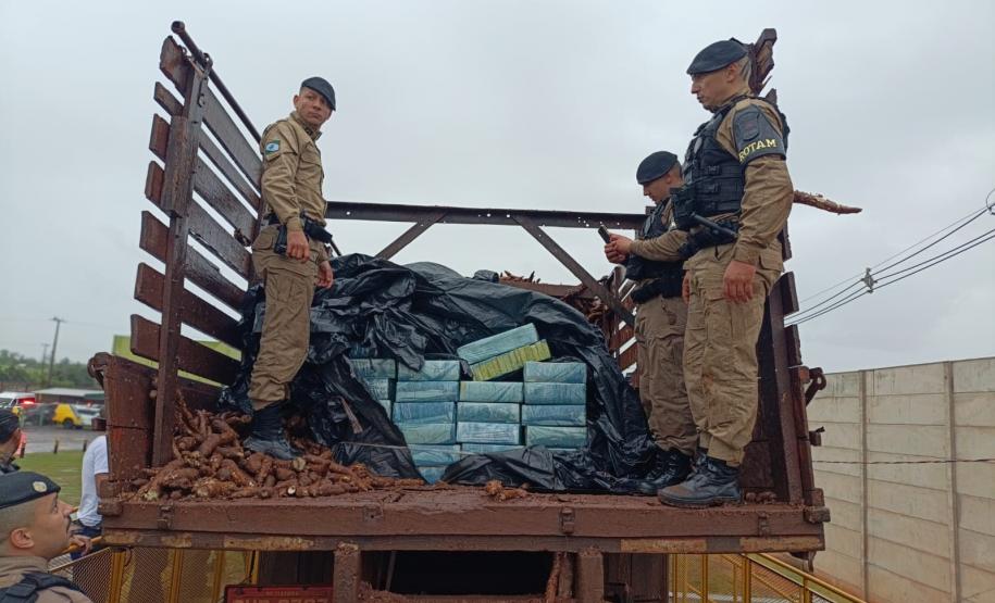 Após buscas detalhadas, os militares estaduais localizaram aproximadamente 5.100 quilos de maconha escondidos sob um carregamento de mandioca