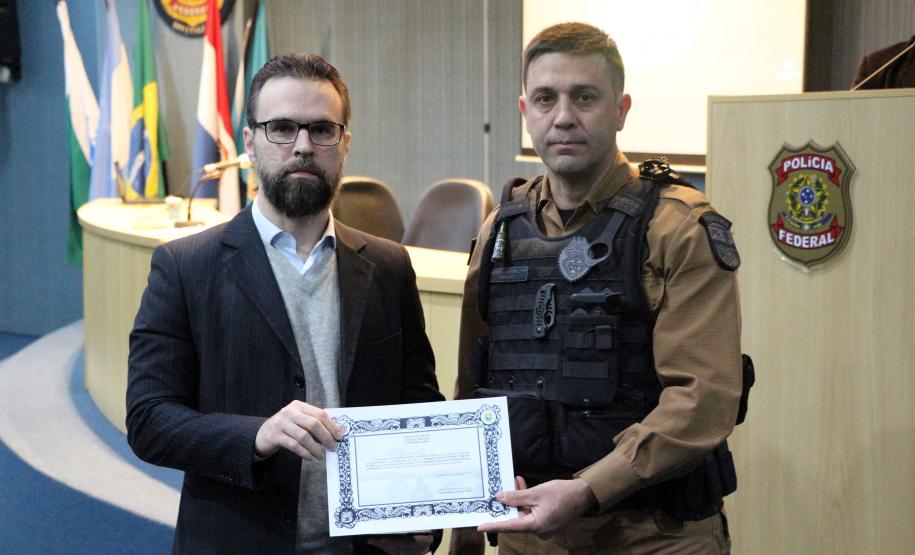 Foz do Iguaçu, 25 de julho de 2019. Simpósio de Operações Policiais Militares de Fronteira. Foto: Ten.-Cel. QOPM Saulo de Tarso Sanson Silva, Comandante do BPFron, em nome do Comandante-Geral da PMPR, faz a entrega do certificado de agradecimento ao Exmo. Sr. Delegado Federal Mozart Person Fuchs.